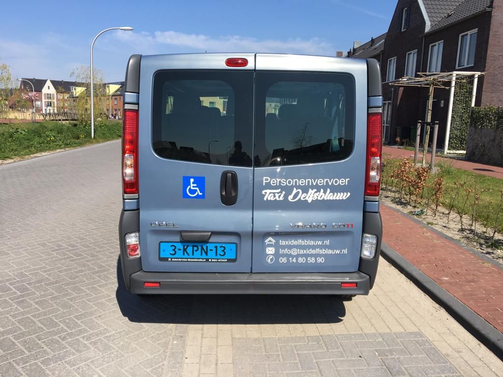 Achterkant van de taxibus met rolstoelsymbool en contactgegevens
