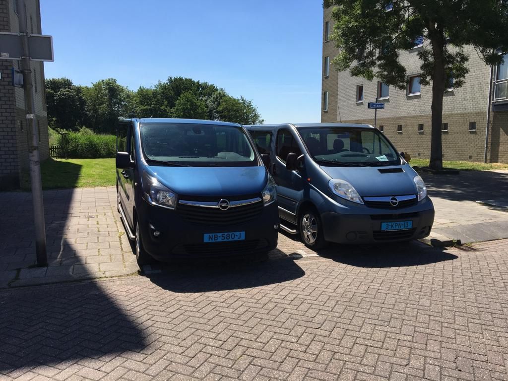 De twee personenbussen van Taxi Delfsblauw naast elkaar geparkeerd